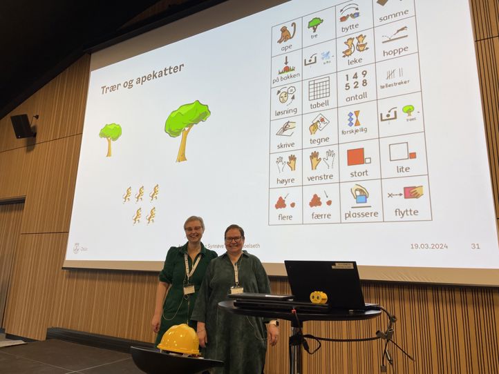 To forelesere avbildet ved powerpoinpresentasjon om ASK-støtte, bilder for trær og apekatter 