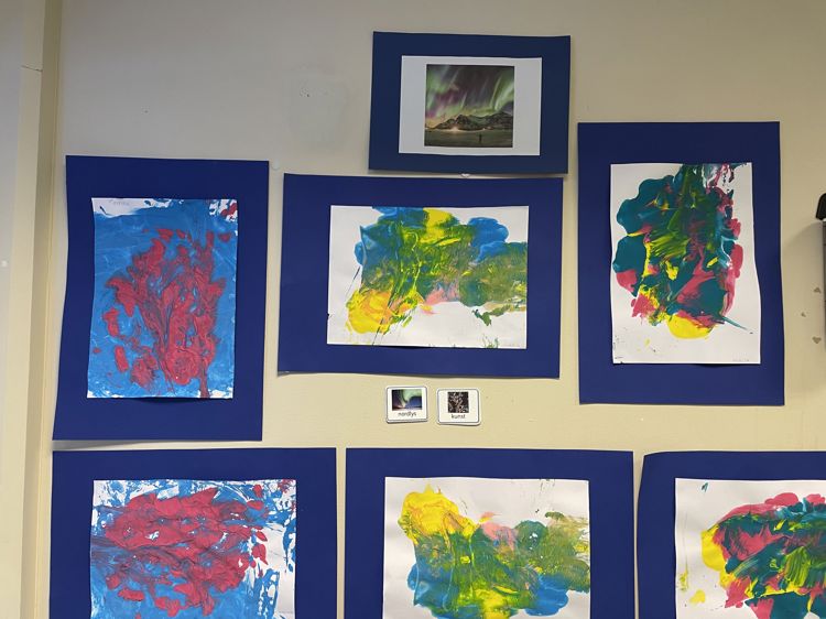 Foto: Haukåsen skole en vegg med bilder, nordlys malt av elevene
